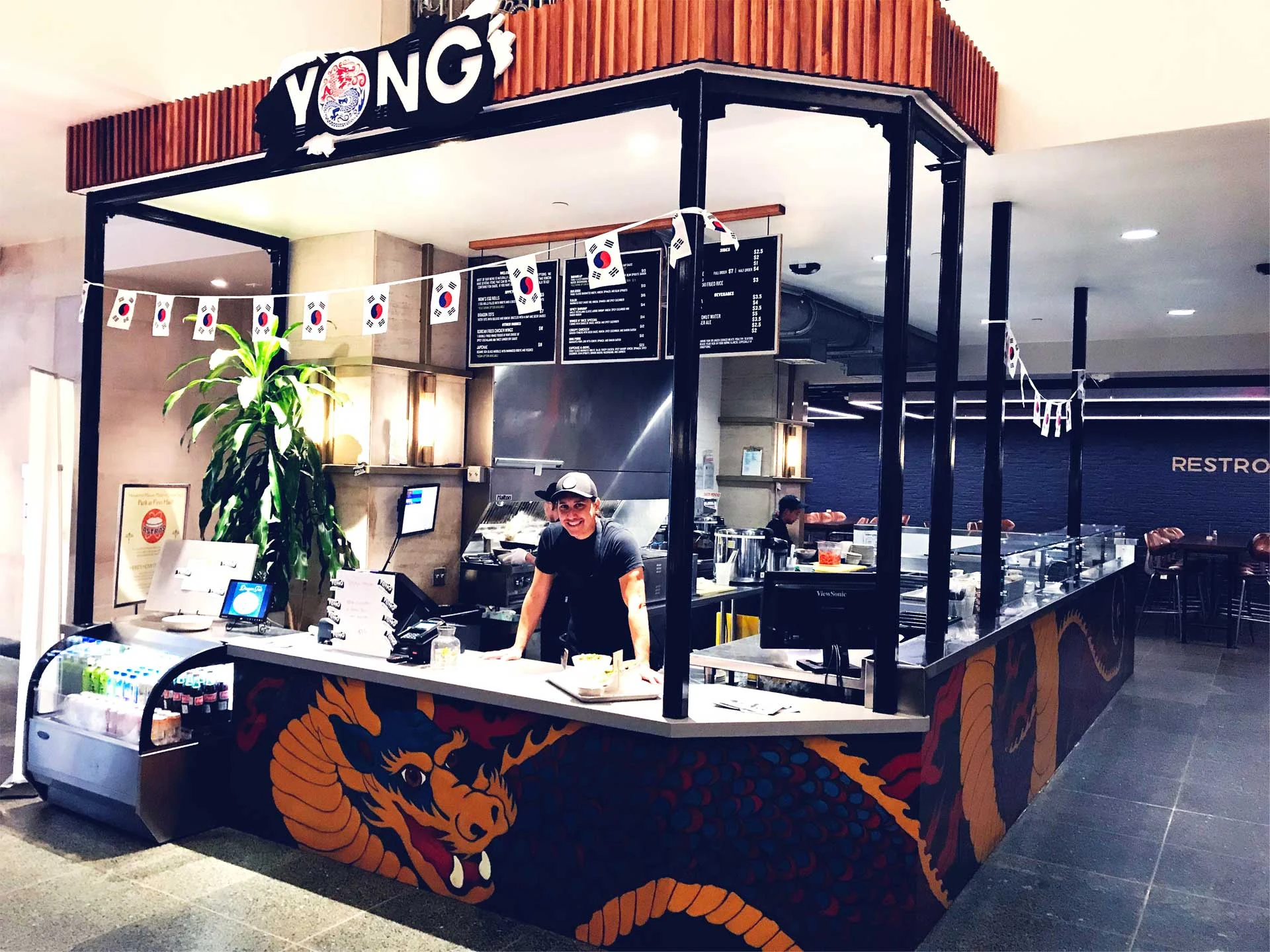 YONG storefront and dragon-wrapped counter inside Finn Hall food hall, Houston