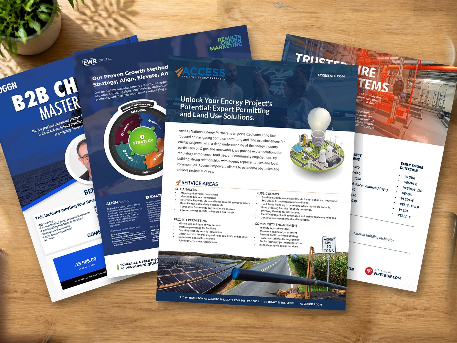 Printed Access National Energy Partners sales sheet designed by Light Sketch Creative, shown flat on a wood desk with pen, glasses and coffee